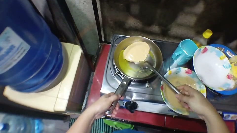 First-person view of hands mixing batter, pouring it into a pan, and flipping a pancake.