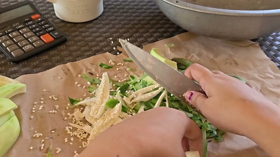 First-person view of hands peeling, sectioning, and slicing a vegetable.